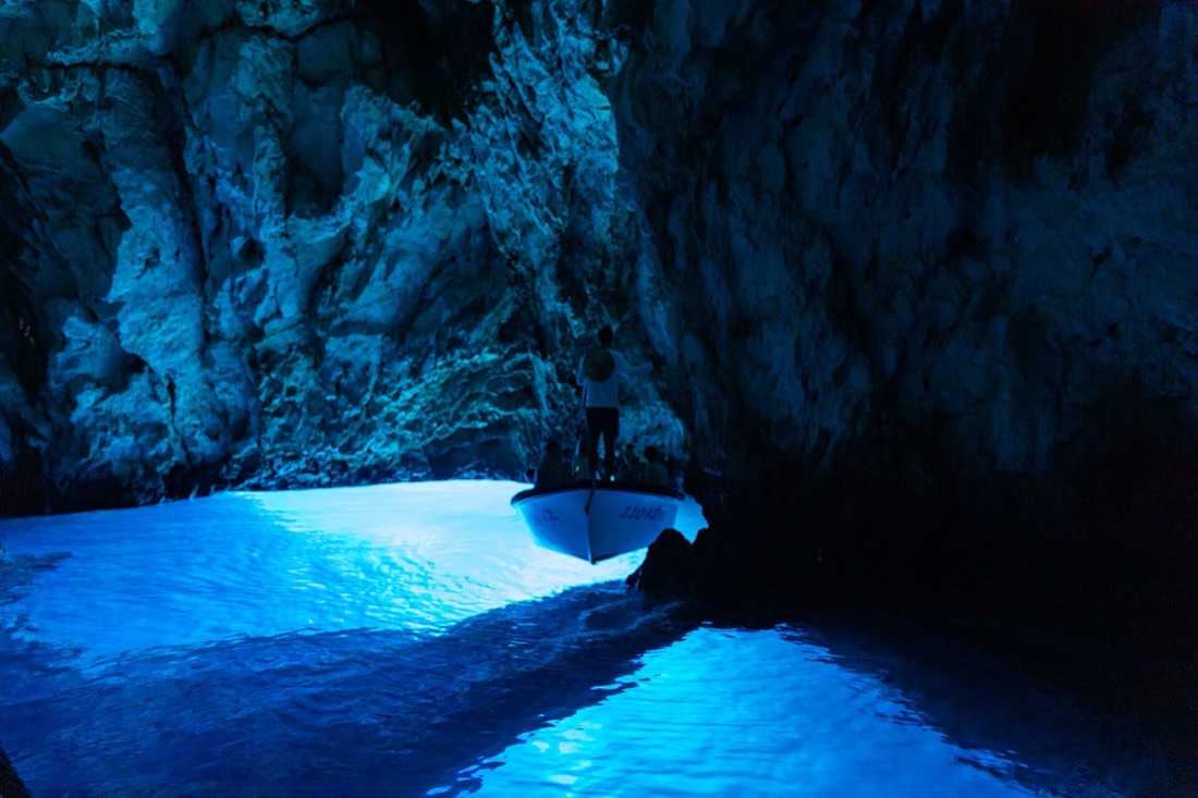 Sunlight glowing electric blue inside a sea cave near Dubrovnik